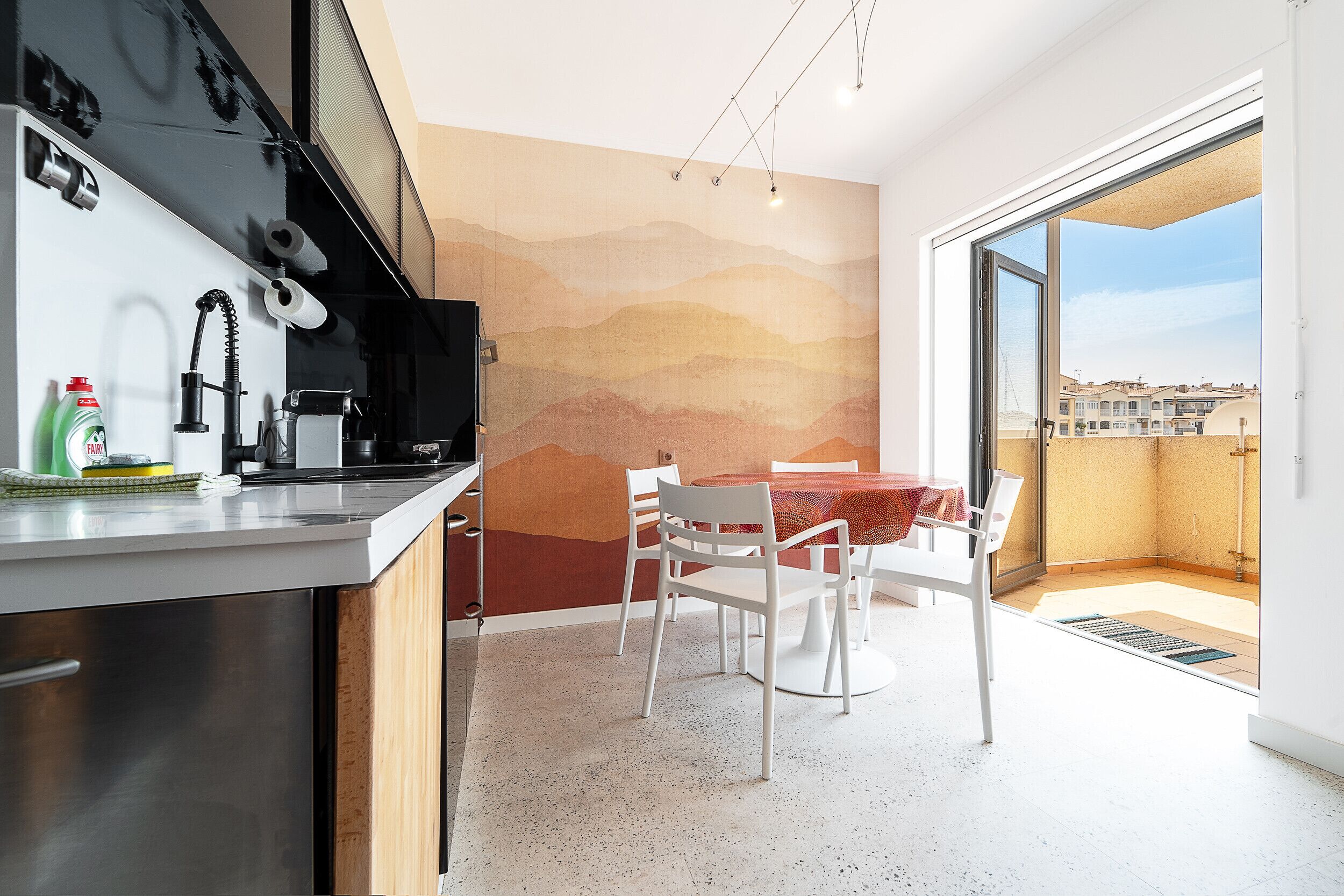 Eine moderne Küche mit Essbereich, einem großen Fenster und Blick auf die Stadt.