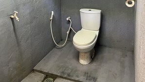A small, narrow bathroom with a toilet, a handwashing station, and a shower. - Cactus Arugambay (Arugam Bay)