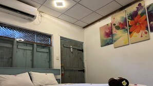 A hotel room with a bed, a window with a view, and a wall with three paintings. - Cactus Arugambay (Arugam Bay)