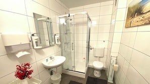 A modern bathroom with a glass-enclosed shower, a white sink, and a toilet. - Gemütliches Zuhause in 1A Lage (Herne)