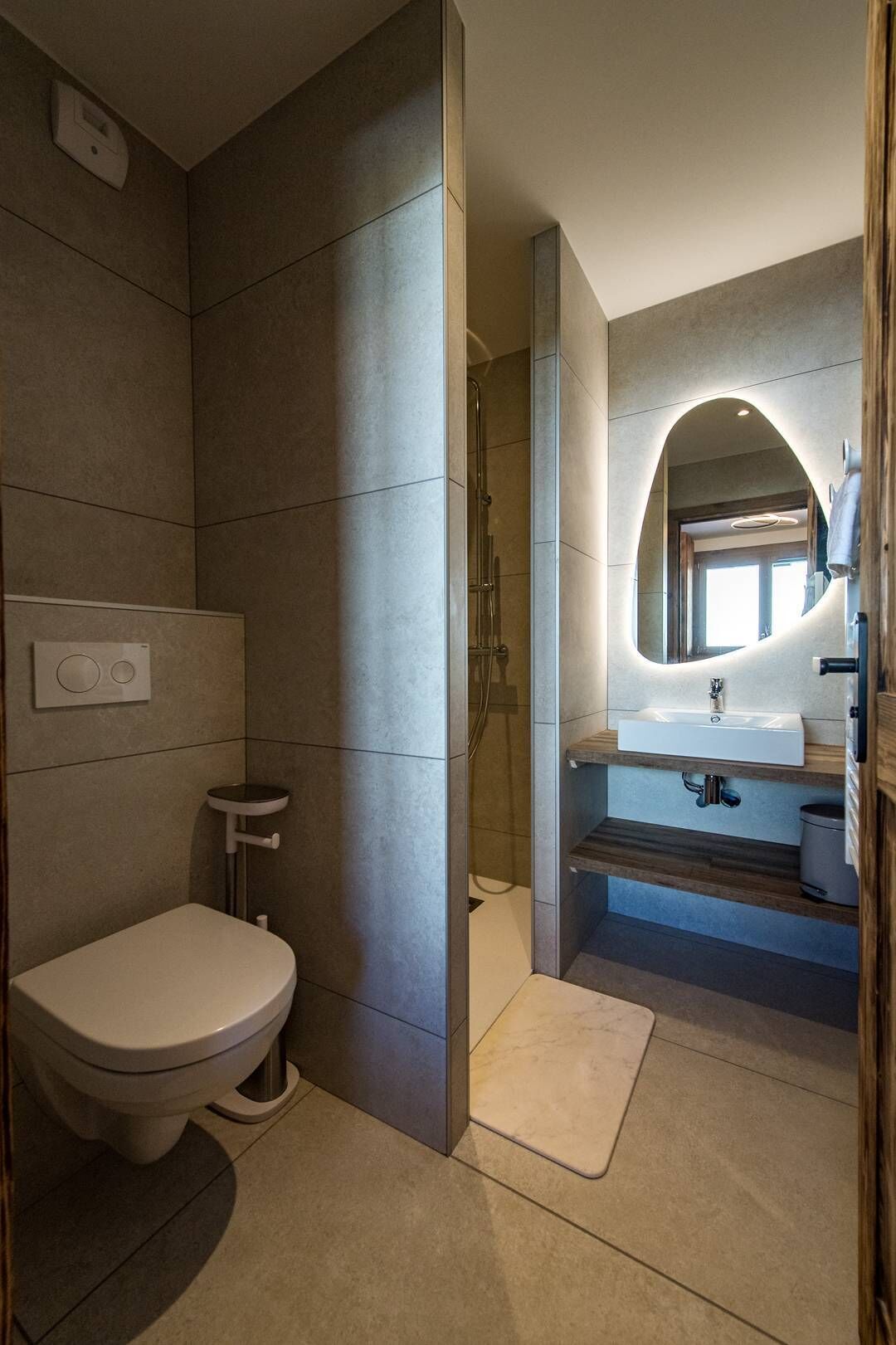 Une salle de bain moderne équipée de toilettes, d’un lavabo et d’un espace douche.