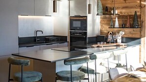 A modern kitchen with a central island, bar stools, and a dining area. - Duplex for 6/8 people in a new residence on the slopes (LA TOUSSUIRE)