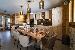 Une cuisine moderne avec des meubles en bois, un îlot central et des luminaires suspendus.
