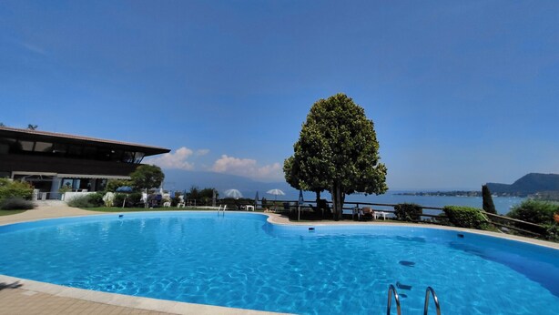 Une piscine offrant une vue dégagée sur la mer et les montagnes en arrière-plan.
