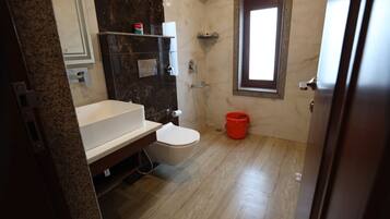Un baño con inodoro, lavabo y zona de ducha.