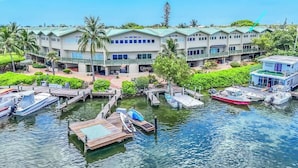 A hotel with multiple buildings, a dock with boats, and a water body. - Serenity Retreat- 2/2 Townhouse, Dock & Pool (Key West)
