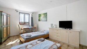 A bedroom with two beds, a desk, a chair, a television, and a wardrobe. - Knödelhof 'Room 9' 3-Bed Room – Guesthouse near Munich (Putzbrunn)