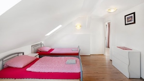 Ein Schlafzimmer mit zwei Betten, einem Schminktisch und einem Dachfenster.