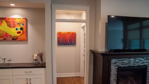 A modern living room with a fireplace, a flat-screen TV, and artwork on the walls. - Cuthbert Place | Single-Level, 1.5mi Mayo, Pets OK (Rochester)