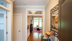 A hallway with wooden flooring, a white door, and a decorative mirror on the right. - Cuthbert Place | Single-Level, 1.5mi Mayo, Pets OK (Rochester)