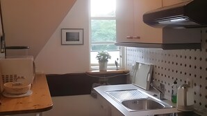 A kitchen with a window, a sink, a stove, and a countertop.