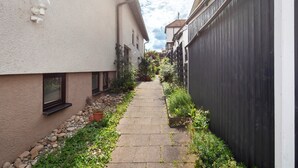 A narrow pathway flanked by buildings, with a stone pathway and potted plants. - M B Homes Nürtingen with Wi-Fi (Nürtingen)