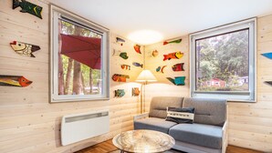 A cozy room with wooden walls, a sofa, a table, and fish-themed decorations.