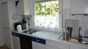 A kitchen with a window, a sink, a stove, and a dishwasher. - Apartment 'Am Eschachwäldle' with Private Terrace, Private Garden and Wi-Fi (Niedereschach)