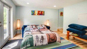 Ein Schlafzimmer mit einem Bett, einer Bank, einer Lampe und einem Bild an der Wand.