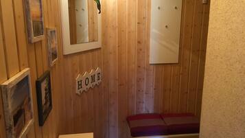 Ein Holzinnenraum mit einer Bank, einem Spiegel und einem Schild mit der Aufschrift 'HOME'.