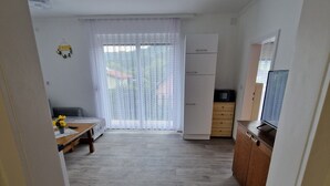 Eine moderne Küche mit Holzarbeitsplatte, einem eingebauten Backofen und einem Fenster mit Vorhängen.