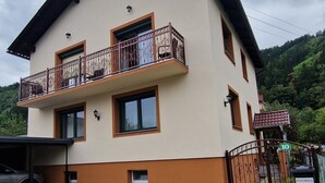 Ein zweistöckiges Gebäude mit Balkon, Garage und Auffahrt.