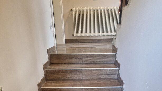 Eine Treppe mit Holzbodenstufen, die zu einer Zwischenebene führen.