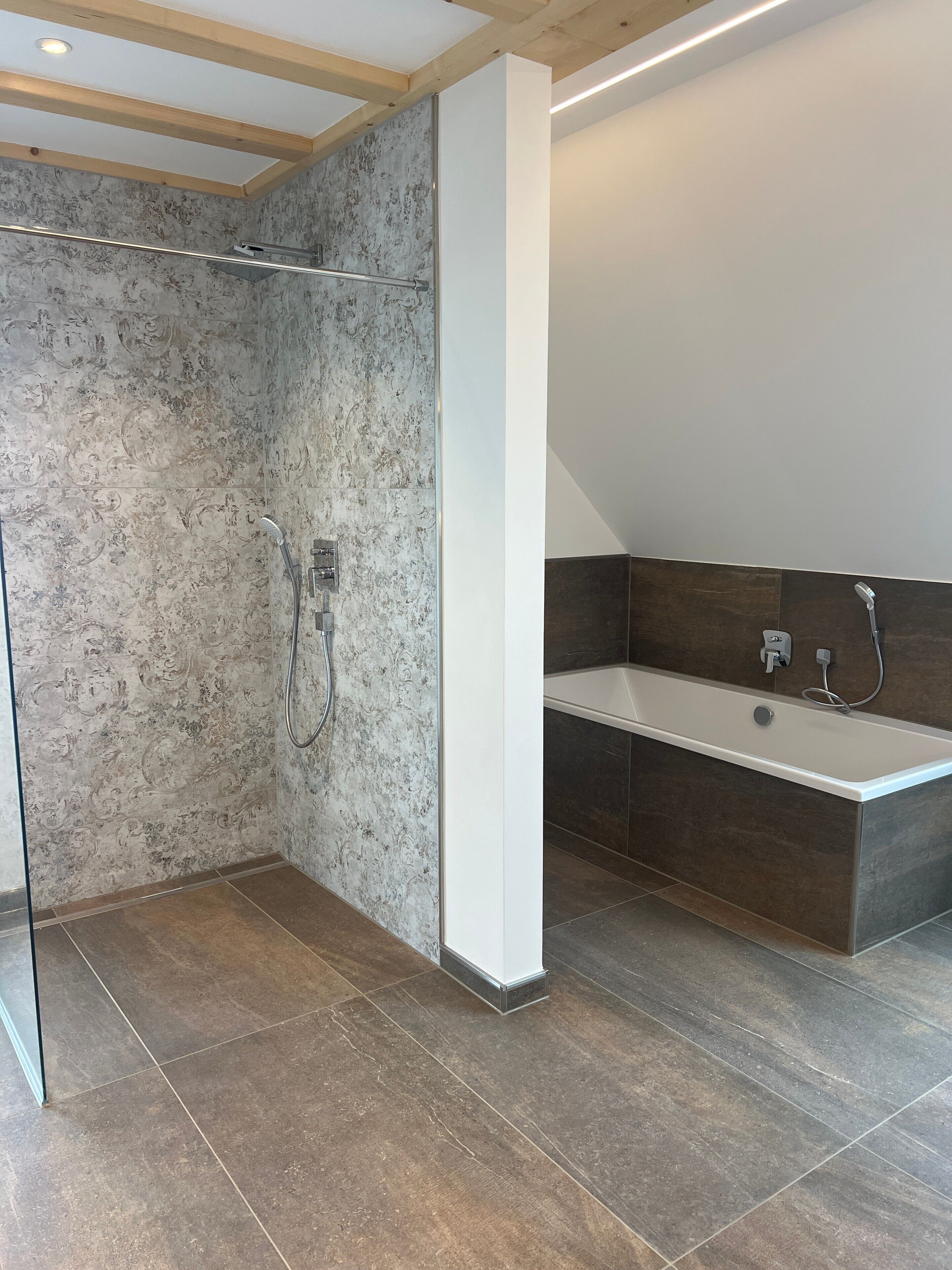 Et moderne badeværelse med brusebad, badekar og vaskebord.