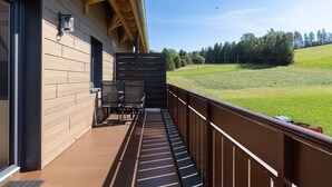 A wooden deck with a view of a green field and trees. - Apartment 'Kapellen Blick' with Mountain View, Shared Terrace and Wi-Fi (Triberg im Schwarzwald)