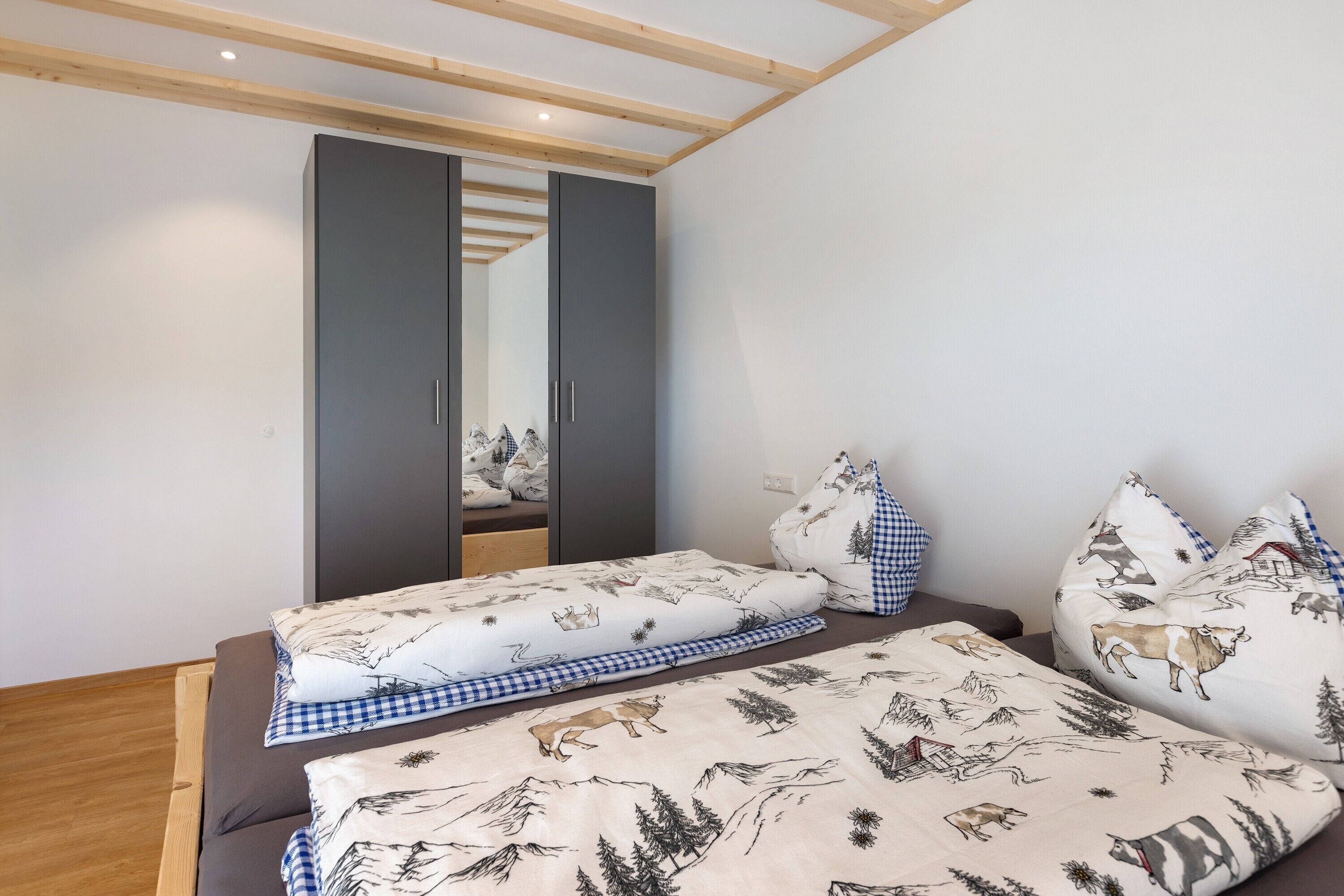 Un dormitorio con cama, armario y espejo.