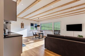 A modern interior with a dining area, sofa, and TV.