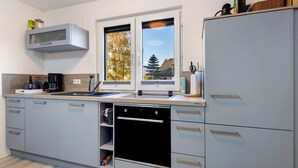 Una cocina moderna con horno integrado, microondas y lavabo.
