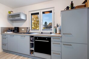 A modern kitchen with a built-in oven, a microwave, and a sink.