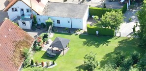 Een woonhuis met een twee verdiepingen tellend huis, een overdekt terras en een keurig onderhouden gazon.