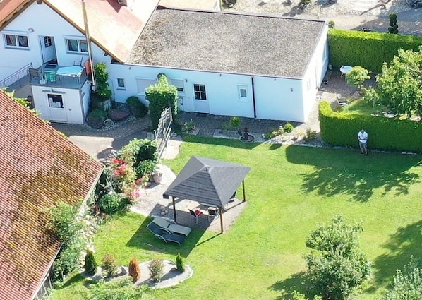 A residential property with a covered patio, a swimming pool, and a well-maintained lawn.