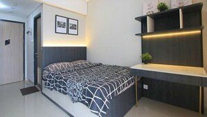 Een moderne slaapkamer met een bed, een bureau en kasten.