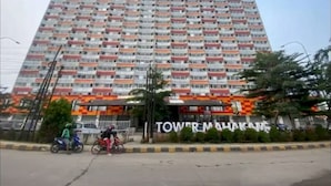 Een hoog gebouw met meerdere balkons, een bord waarop 