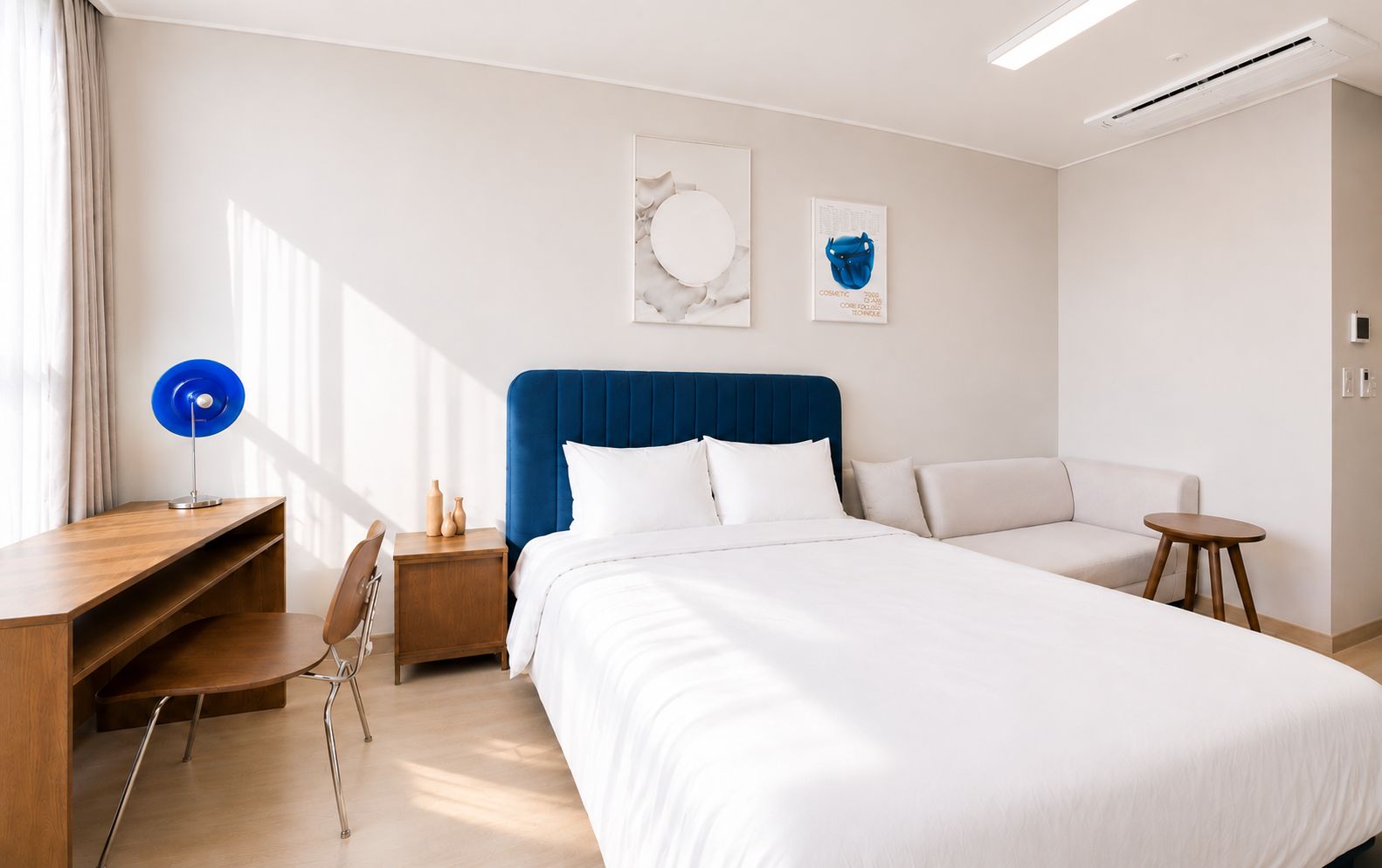 Una habitación de hotel con una cama grande, un escritorio, una silla, una mesita y un sofá.