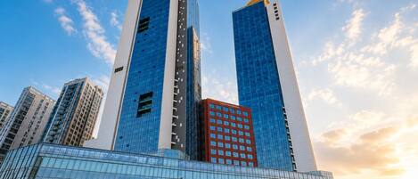 A modern high-rise building with reflective glass windows and a prominent 'CH' logo on the top.