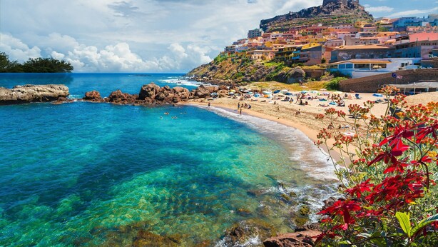 A coastal town with clear blue waters, a sandy beach, and colorful buildings. - Trilo Vista Mare-residence La Smeralda (Castelsardo)