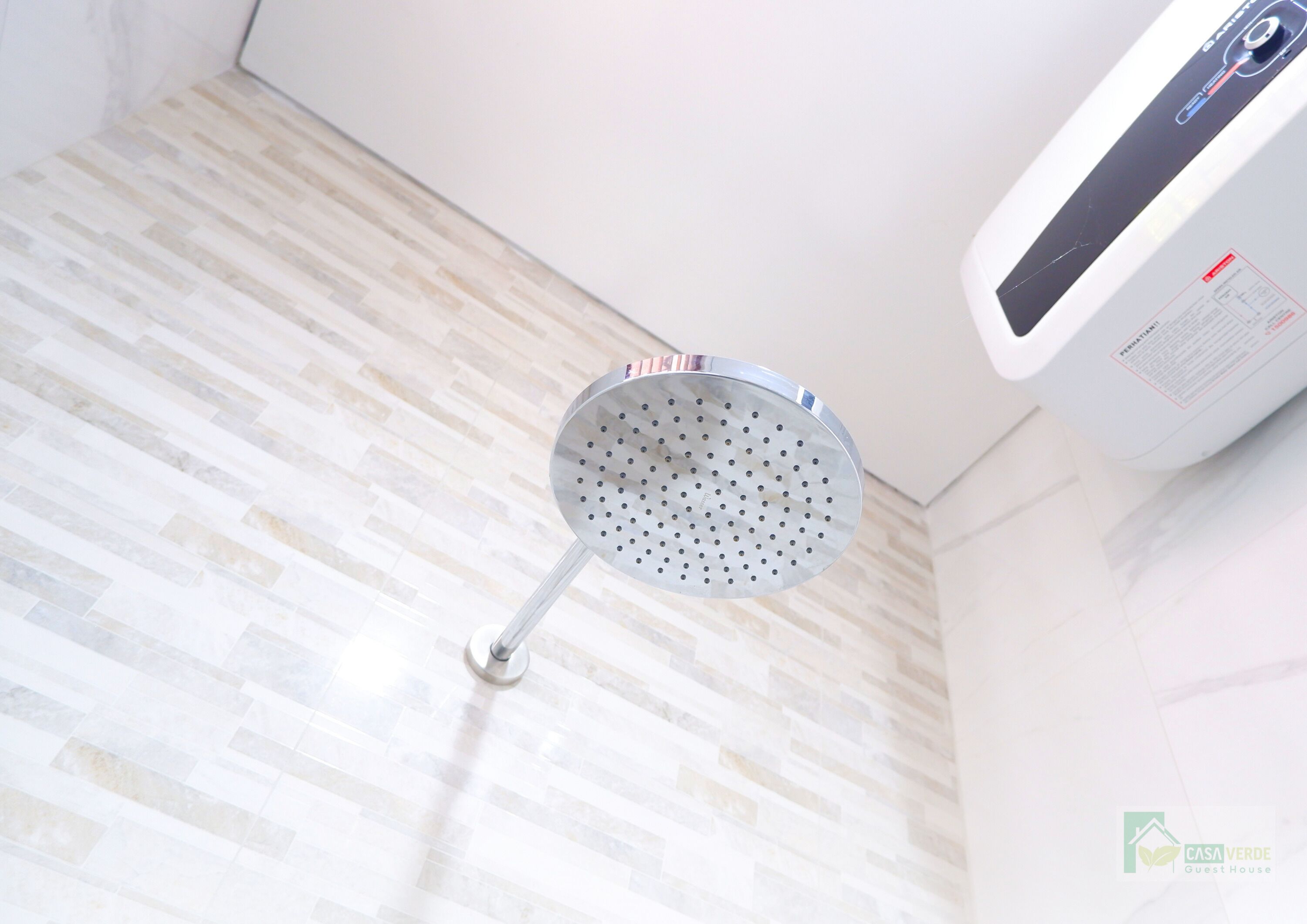 A showerhead mounted on a tiled wall in a bathroom.