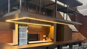 A modern bar area with a counter and bar stools. - Casa Verde Guesthouse (Mengwi)