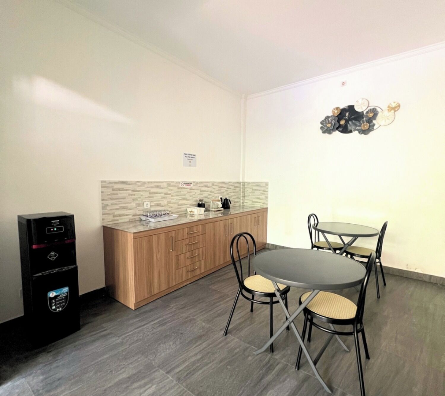 Une cuisine compacte dotée d’un plan de travail en bois, d’une cuisinière intégrée et d’un coin repas avec une table ronde et quatre chaises.