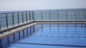 A swimming pool with a glass barrier and a view of the ocean. - Stay next to the sea but central to all your need.  (Colombo)