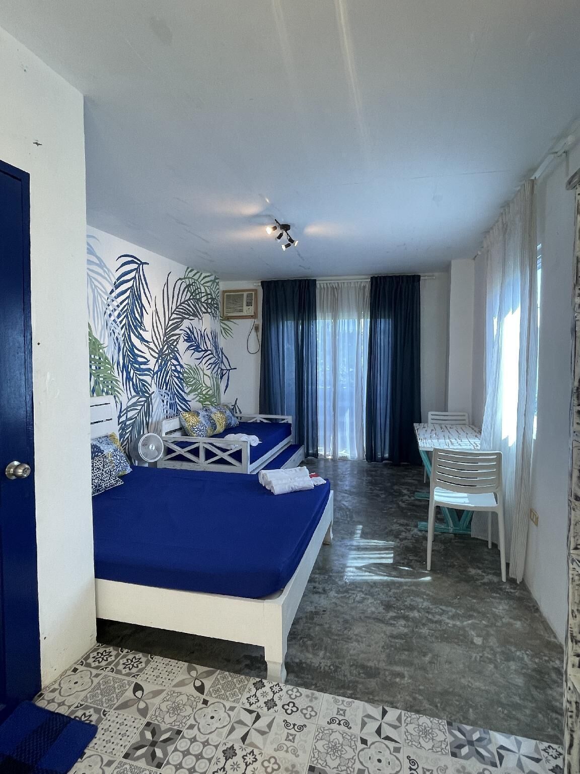 Una habitación con una cama, una mesa y una silla.