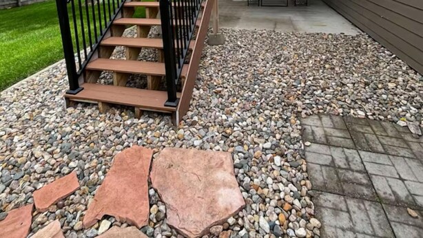 A residential outdoor area with a wooden staircase, a patio with a table and chairs, and a garden with a variety of plants and trees. - 3-BR vacation home with 2 spacious entertaining areas: Sleeps 11, 4 miles to DT (Sioux Falls)