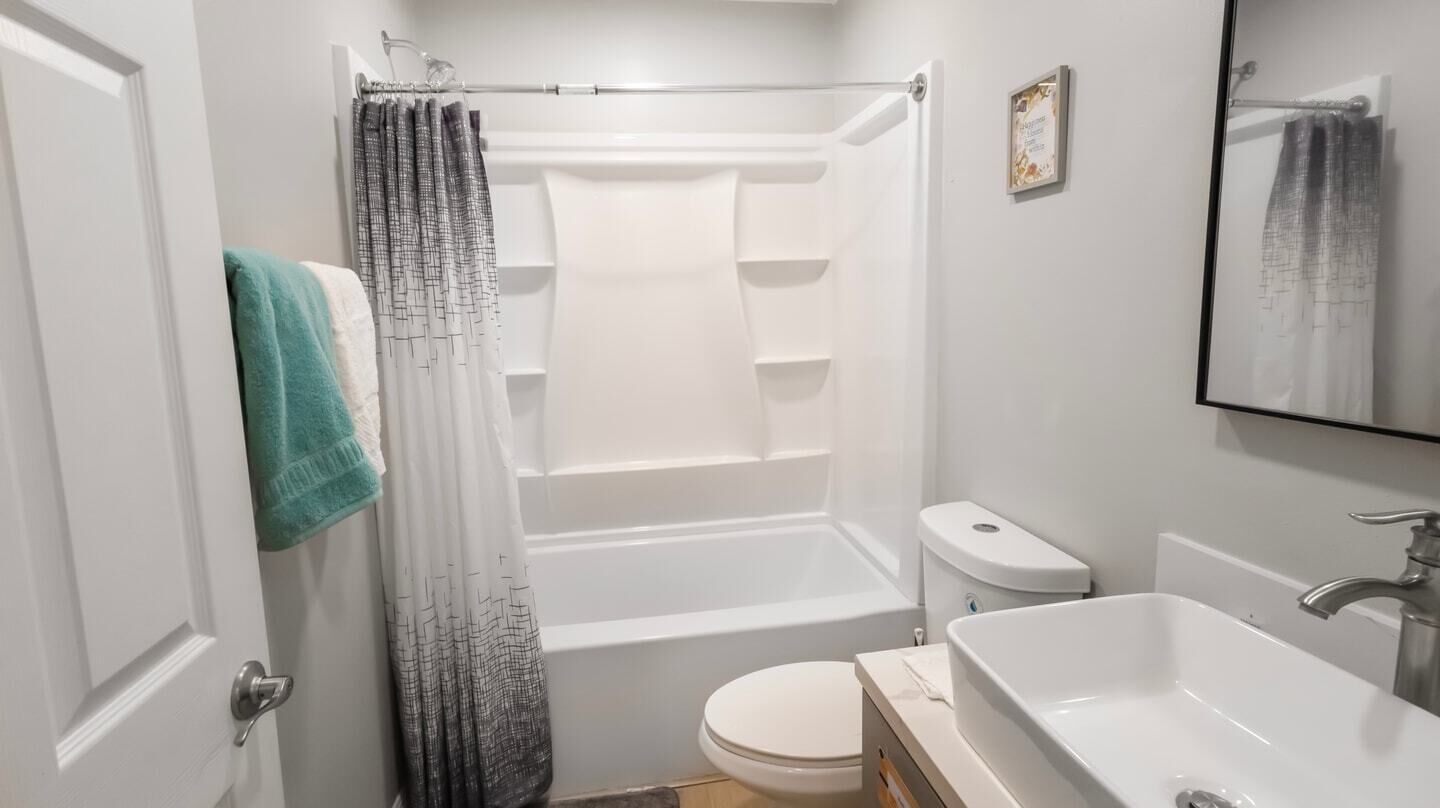 A modern bathroom with a bathtub, toilet, and sink.