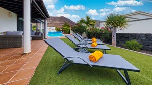 A poolside area with lounge chairs and a covered seating area. - Villa Endless Summer - Pool and BBQ By LVH (Playa Blanca)