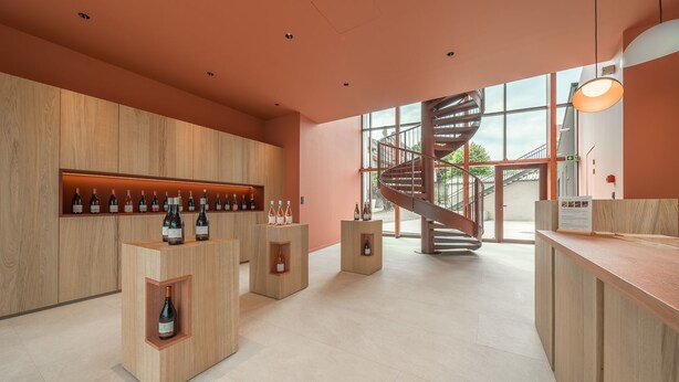 Een modern interieur met houten lambrisering, een spiltrap en een wijnrek.