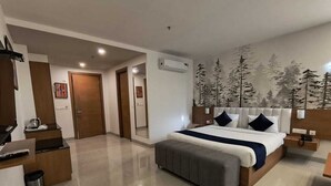 A modern hotel room with a large bed, a desk, and a bathroom. - V Club Sohna Road (Gurugram)