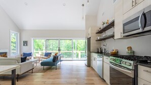 A modern kitchen with a built-in stove, microwave, and stainless steel appliances. - Airy Tree Canopy Home w/ Creek Views & Family Suite (Sparrow Bush)
