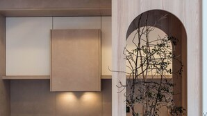 Eine moderne Küche mit integrierten Geräten, Holzschränken und einem Rundfenster mit einer Pflanze.
