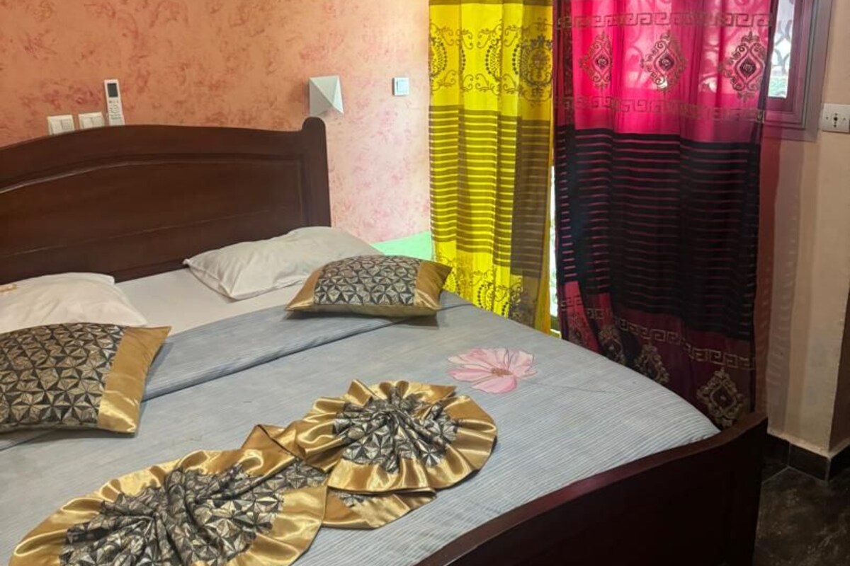 A bedroom with a bed, pillows, and curtains.