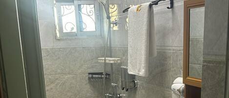 A bathroom with a toilet, sink, and shower.